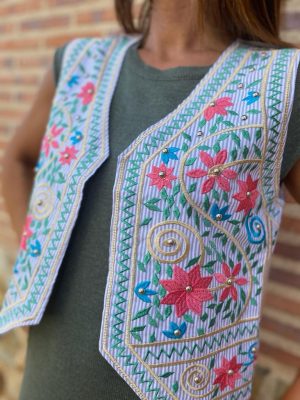 detalle de las tachuelas en el chaleco de flores azul