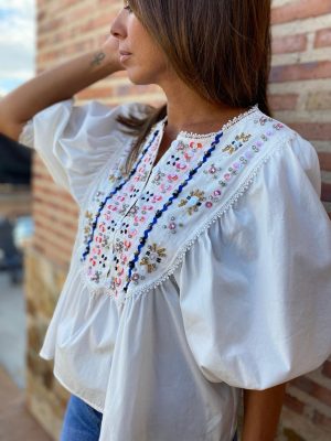 modelo posando con la camisa lidia blanca y piedras en el pecho