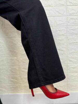 detalle del bajo del pantalon negro con 5 bolsillos